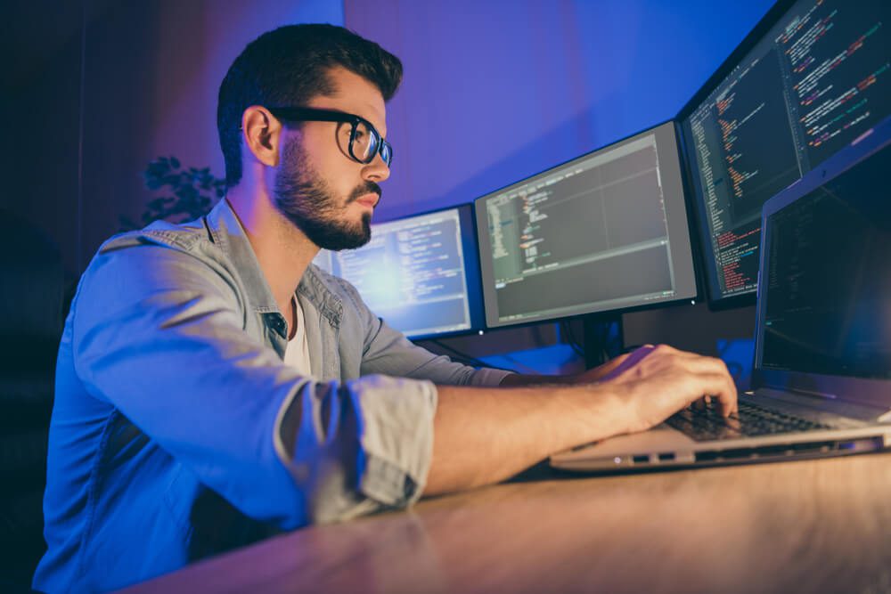 technical seo expert_Profile side view portrait of his he nice attractive focused skilled guy writing cyber attack hack web network hardware software protection trouble shooting in dark room workplace station