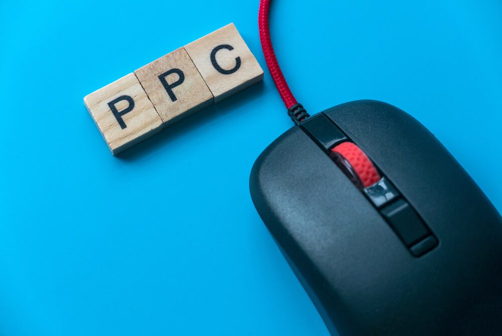 pay per click_PPC Pay Per Click with alphabet and mouse on blue background.
