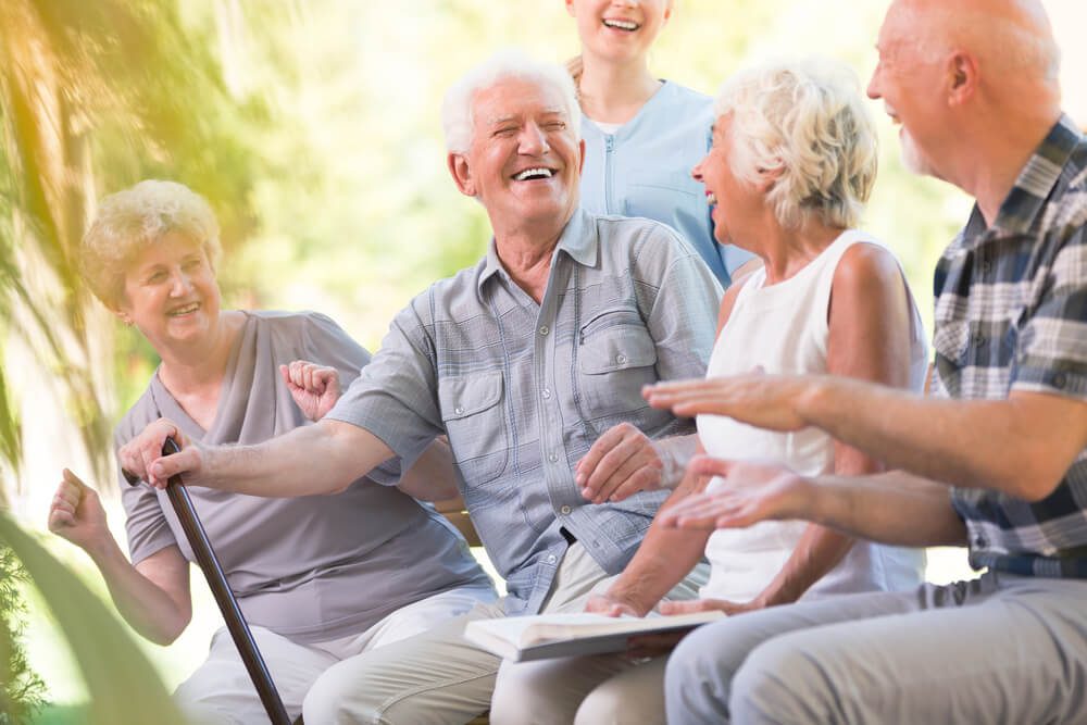 senior_Group of smiling senior friends spending time together sitting in the park