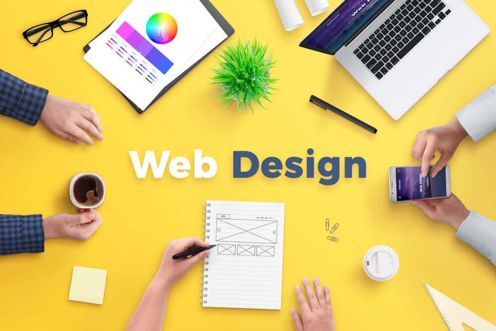 web design_Web design team work on project concept. Yellow desk with web design text. Top view, flat lay.