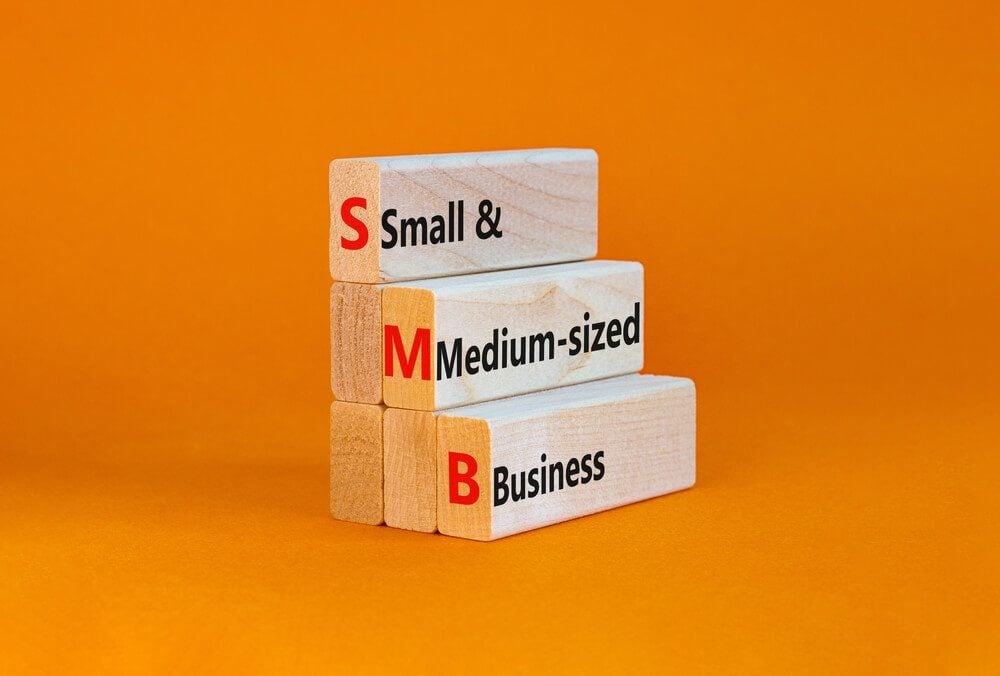 SMB_SMB small and medium-sized business symbol. Words SMB small and medium-sized business on blocks on a beautiful orange background. Business and SMB small and medium-sized business concept. Copy space.