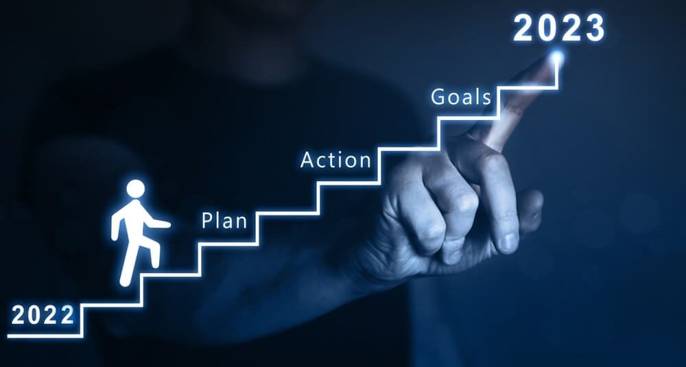 fintech marketing tips for startupsNew Year 2023 with plan, action and goals.Businessman pointing to the growing plan of successful business in 2023 year and a figure climbs the ladder of success.