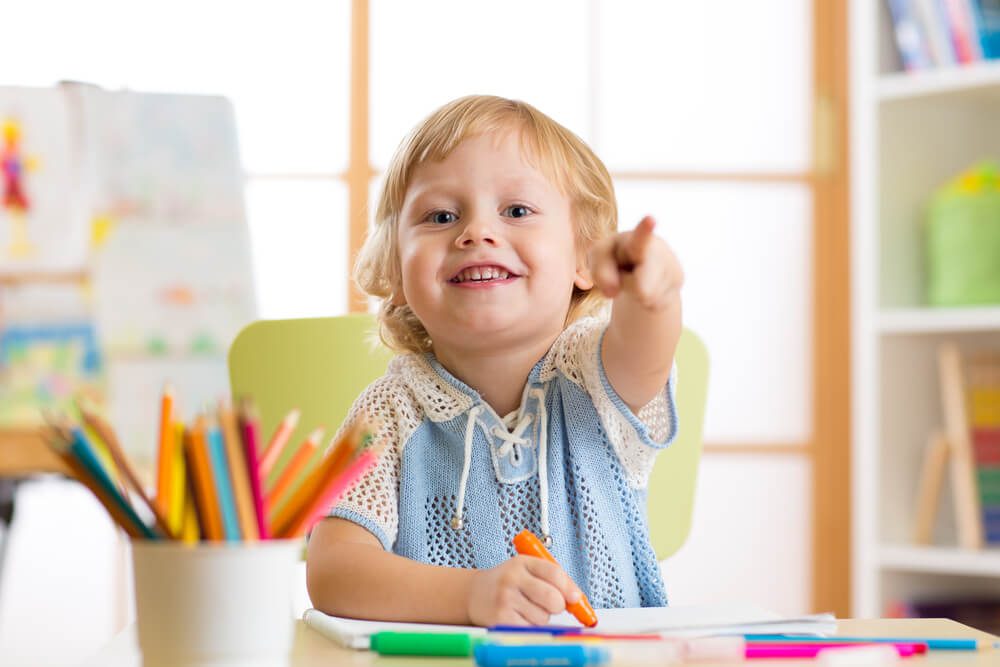 daycare seo_cute little boy drawing with felt-tip pen in kindergarten classroom