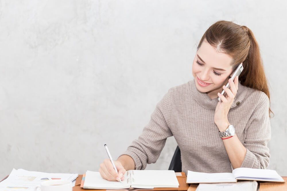 check reference_Caucasian Business woman writing down requirement to book and talking with customer in smartphone,Feeling so happiness and working with service mind,Business and Finance Concept