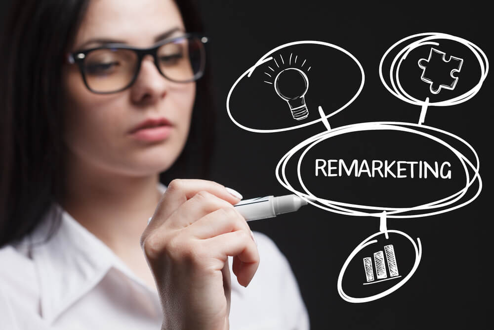 remarketing_The concept of business, technology, the Internet and the network. A young entrepreneur working on a virtual screen of the future and sees the inscription: Remarketing