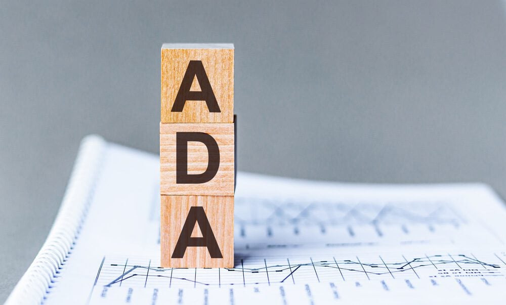 ADA Compliant_Word ADA Americans with Disabilities Act is made of wooden blocks, grey background