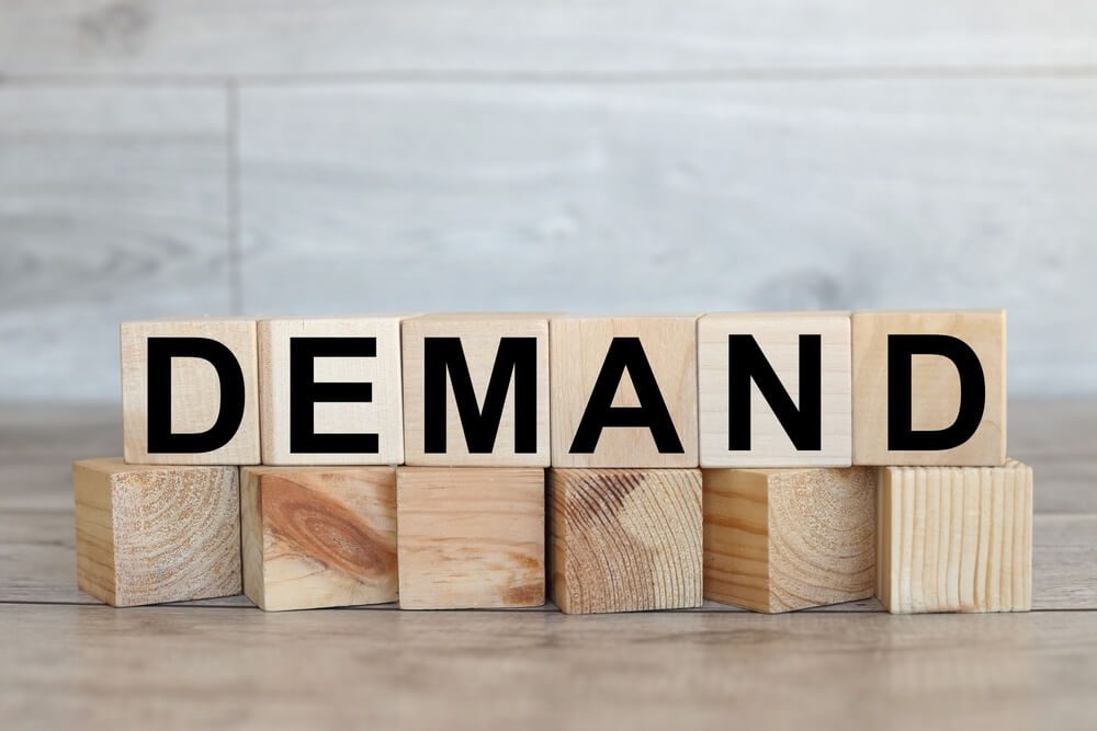 demand_The word demand on stacked wooden cubes. Demand increase or rise in economy or business concept.