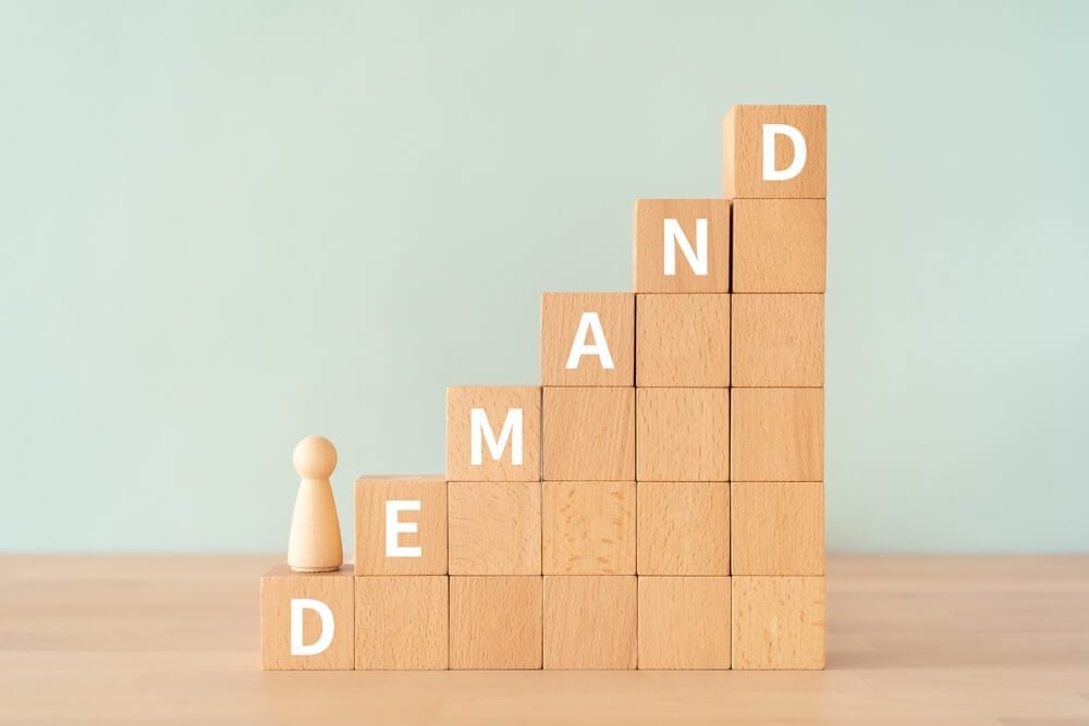 demand strategy_Wooden blocks with "DEMAND" text of concept and a human toy.