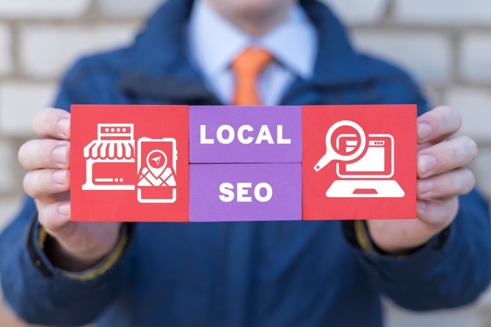 local SEO_Man holding colorful blocks with icons and inscription: LOCAL SEO. Local search marketing e-commerce. Concept of local seo strategy, local search optimization.