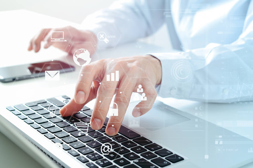 PPC_close up of businessman using mobile phone and laptop computer on white desk in modern office with VR icons diagram