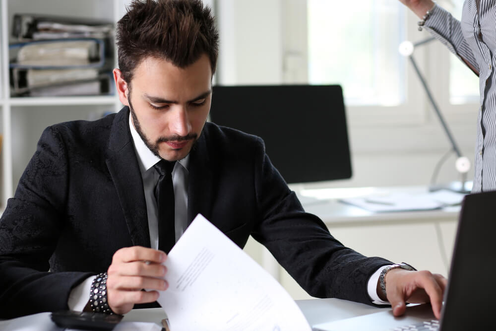 FCMO_Handsome businessman in suit portrait at workplace holding clipboard pad. White collar worker at workspace, exchange market, job offer, certified public accountant, internal Revenue officer concept