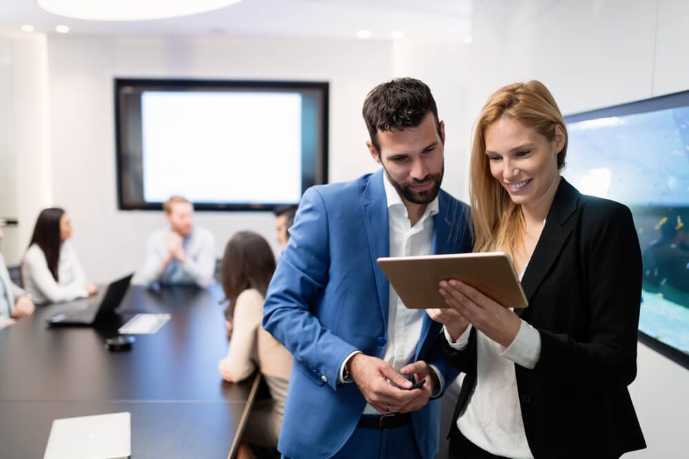 CMO_Attractive business couple using tablet in modern office