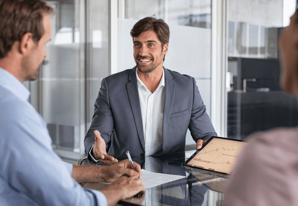 digital consultant_Confident financial agent showing growth graph to couple. Mid couple meeting financial advisor for investment. Business people discussing the charts and graphs showing the results of their successful teamwork.