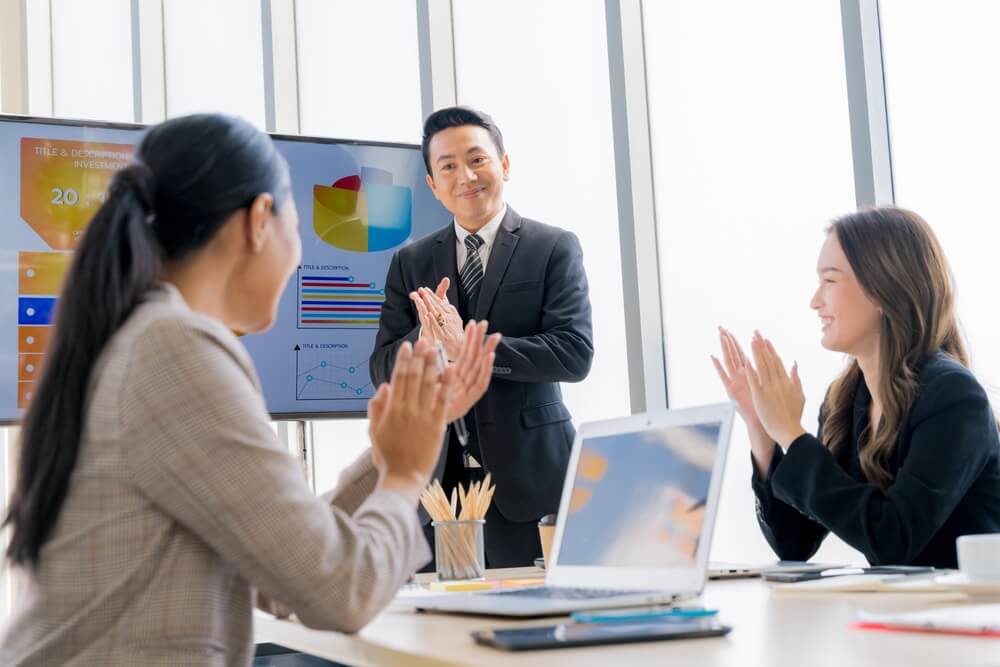 CMO_Cheerful young Asian businessman Excited and glad applauded. About successful startup projects Happy Asian colleagues celebrating business success in office meeting.