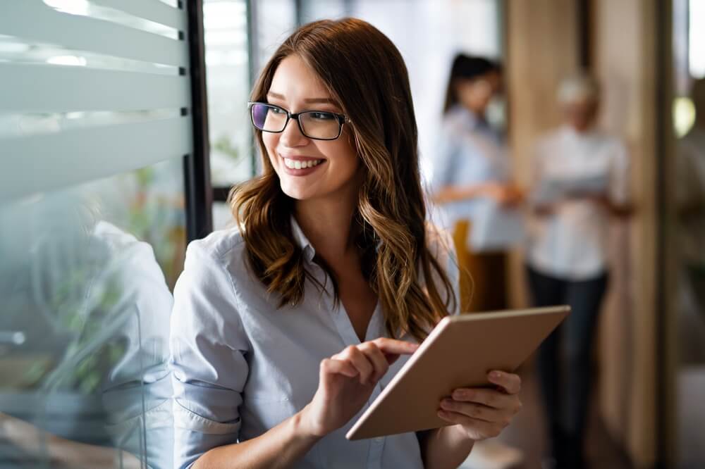 professional_Young happy business woman working with tablet in corporate office