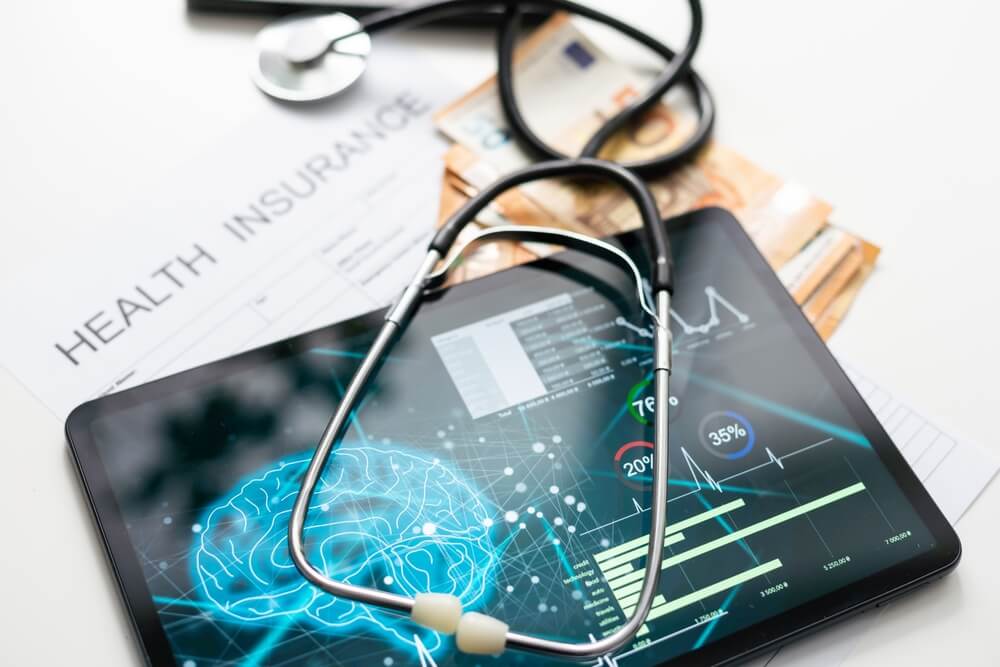 healthcare digital marketing_Modern social health insurance program. Tablet computer with healthcare application interface on screen. Stethoscope, x-ray image and cardiogram on wooden desk. Digital healthcare technologies