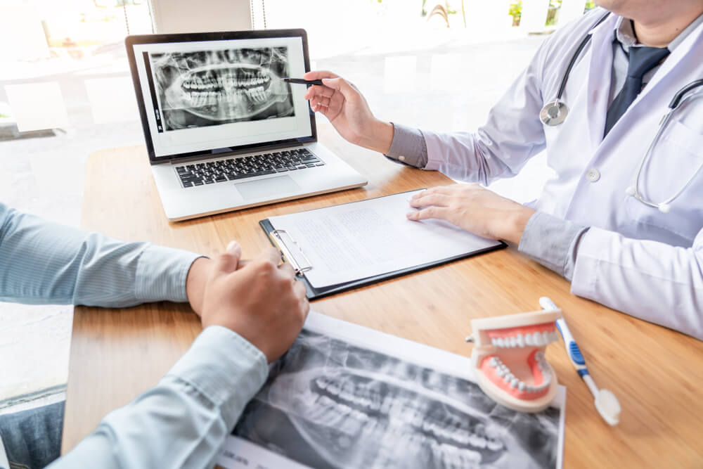 dentist content_Medical team discussing, health care talking to female patient, Medical conferrence concept, doctor holding and looking at dental x-ray attending a client