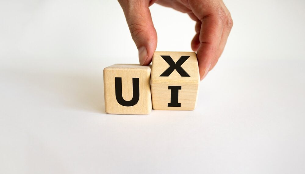 UI and UX_UX design or UI design. Male hand turns cube and changes word 'UX - user experience' to 'UI - user interface'. Beautiful white background. Business and UI or UI concept. Copy space.