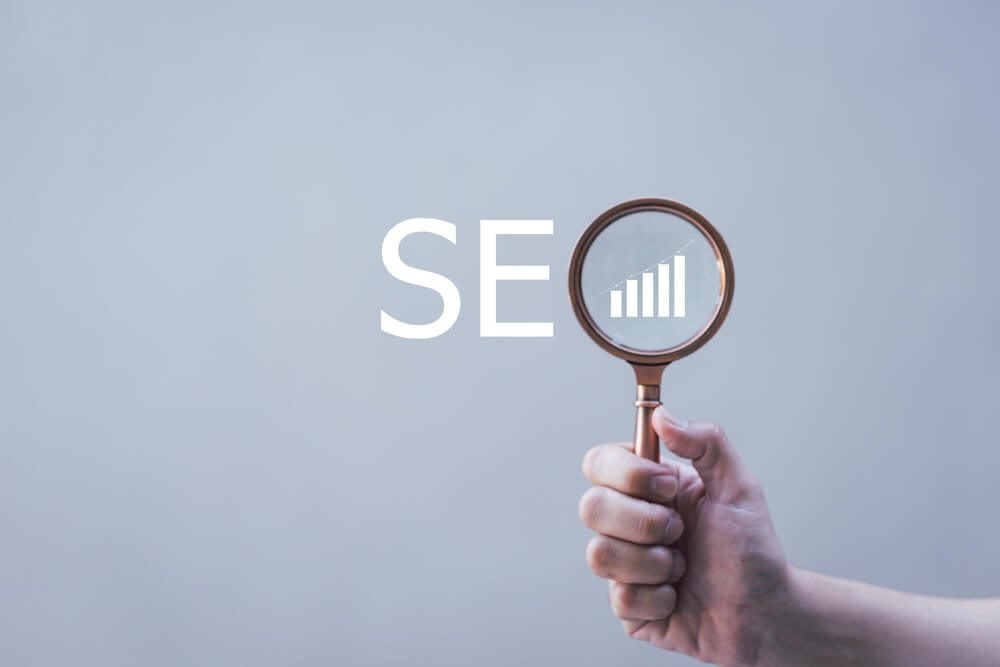 SEO_SEO Search Engine Optimization, Businessman holding through magnifying glass with text SEO, concept for promoting ranking traffic on website, optimizing your website to rank in search engines.