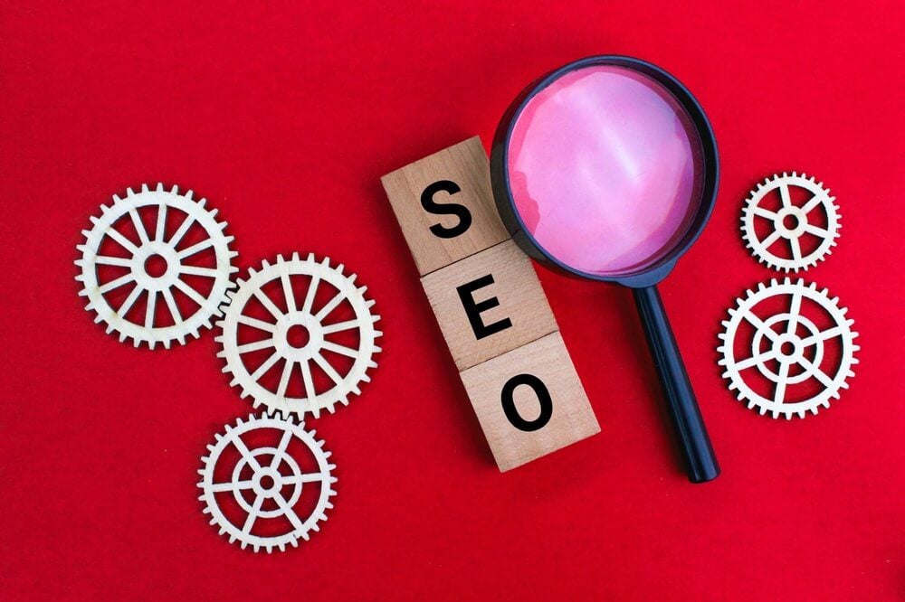 SEO guide_magnifying glass and gear teeth with the letters SEO or the word Search Engine Optimization