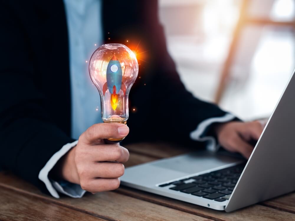 SEO branding_Startup business concept. Launching up the rocket, 3d graphic in creative idea light bulb holding by businessperson hand who working with laptop computer. Creative motivation for successful business