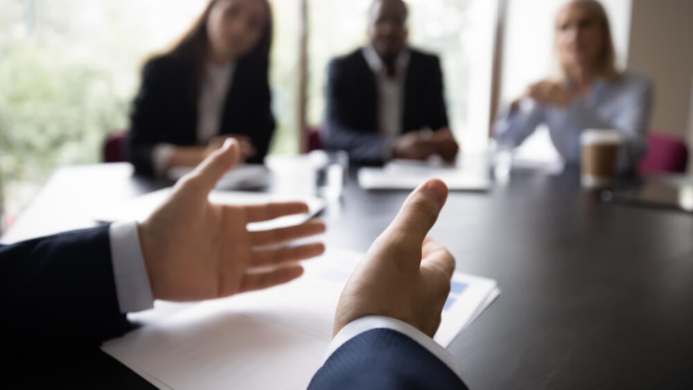 CMO_Hands of business leader, executive, boss, coach talking to diverse team, explaining marketing reports to employees, speaking before audience on office meeting, conference. Cropped banner, close up