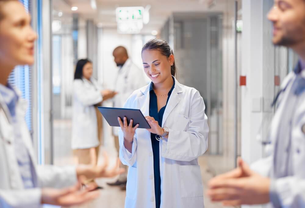 hospital software_Happy woman doctor on tablet for employees management, hospital workflow and clinic staff solution on software or app. Healthcare manager on digital tech for medical team research or problem solving