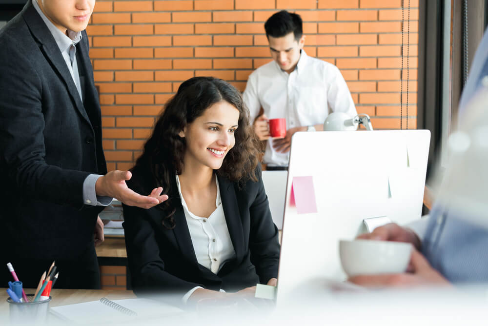 fractional CMO_Smiling businesswoman working with her colleagues in creative office