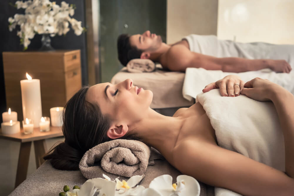 Spa_Young man and woman lying down on massage beds at Asian luxury spa and wellness center