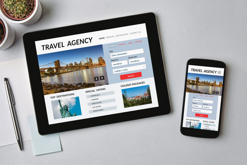 travel and tours agency_Travel agency concept on tablet and smartphone screen over gray table. All screen content is designed by me. Flat lay