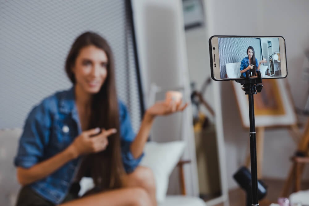 influencer marketing_Blogger of caucasian woman with review product and talking camera live recording video on social network at home. Online merchants selling cosmetics on social media via mobile phones.