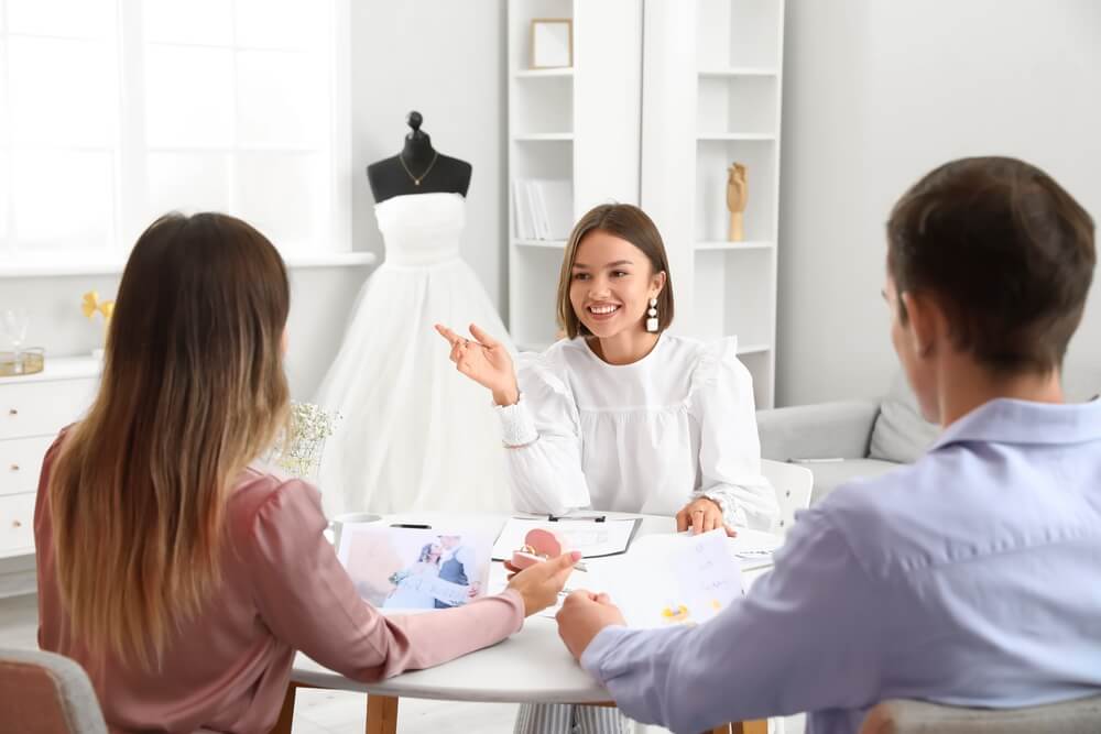 wedding planner_Female wedding planner discussing ceremony with clients in office