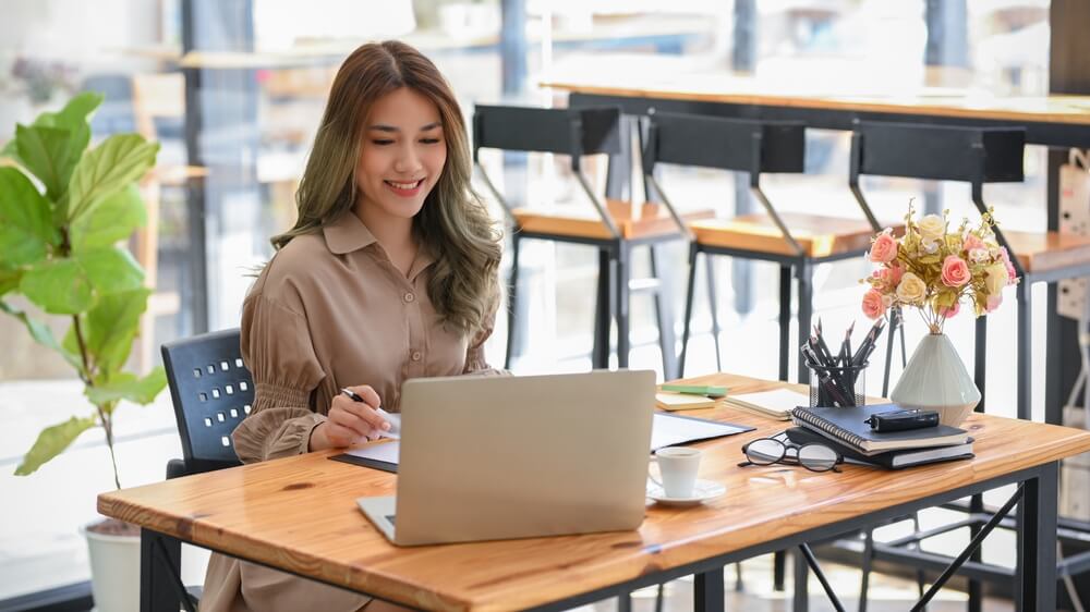 CMO_Attractive asian woman officer or businesswoman remote working at cafe co-working space, working on laptop computer.