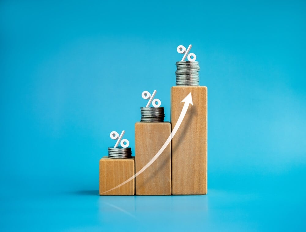 profitability_Shining rise up arrow on wooden cube blocks with percentage icon on coin stacked, bar graph chart steps, investment, profit, benefit, income, banking, business growth, economic improvement concepts.
