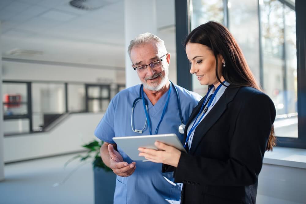 hospital campaign_Young pharmaceutic seller explaining something to doctor in hospital.