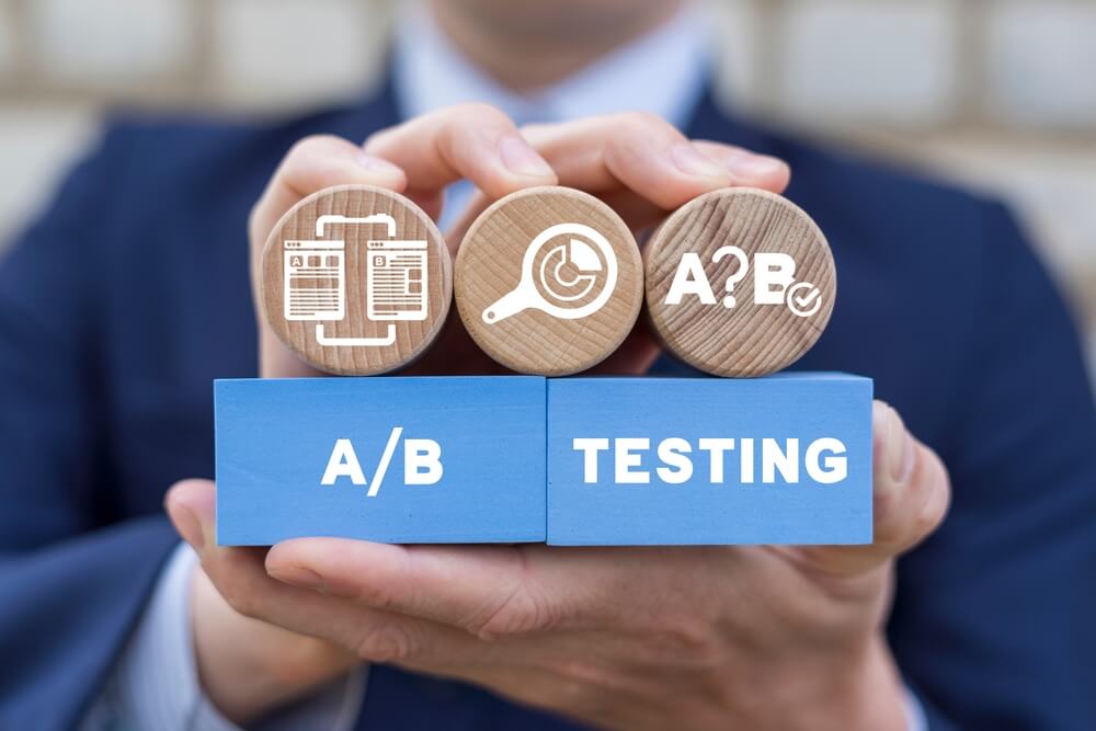 a/b testing_Man holding colorful styrofoam blocks sees inscription: A B TESTING. AB testing wireframe campaign for web website home homepage. AB Testing Method. Internet pages A-B comparison and split testing.