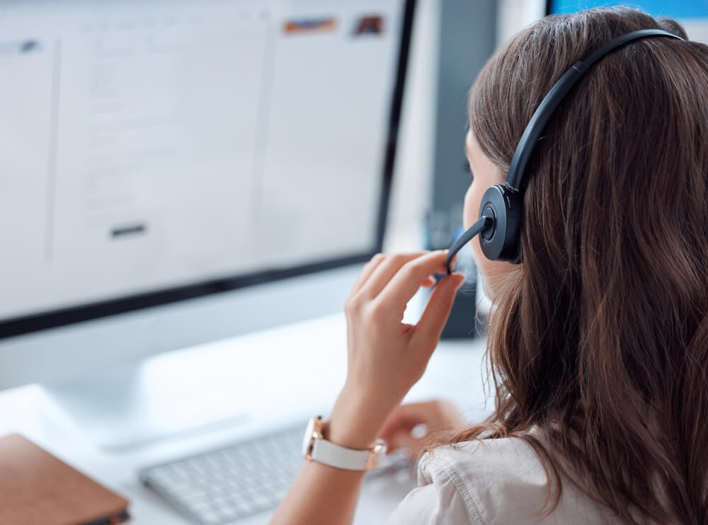 customer support_Customer support, call center and back of female agent working on online consultation in the office. Telemarketing, communication and saleswoman planning crm with headset and computer in workplace.