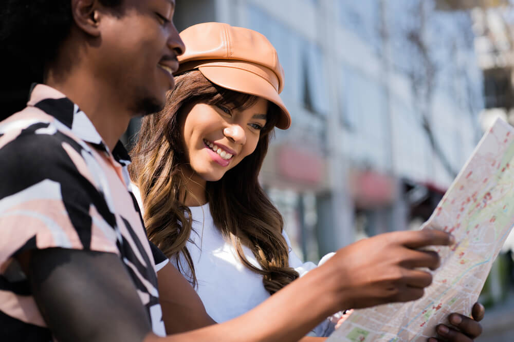 walking tours_Young tourist couple looking at map outdoors.