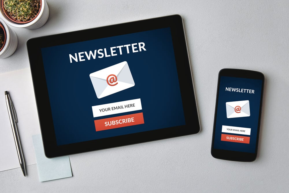email newsletter_Subscribe newsletter concept on tablet and smartphone screen over gray table. All screen content is designed by me. Flat lay
