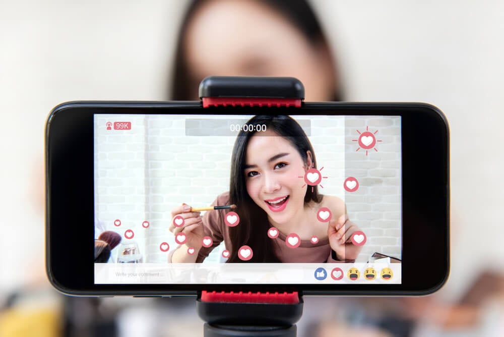 influencer marketing_Asian woman professional beauty vlogger or blogger live broadcasting cosmetic makeup tutorial viral video clip by smartphone sharing on social media