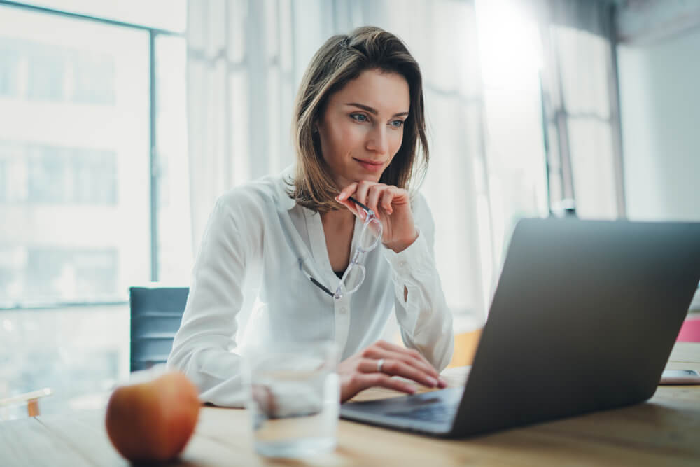 CMO_Confident businesswoman working on laptop at her workplace at modern office.Blurred background