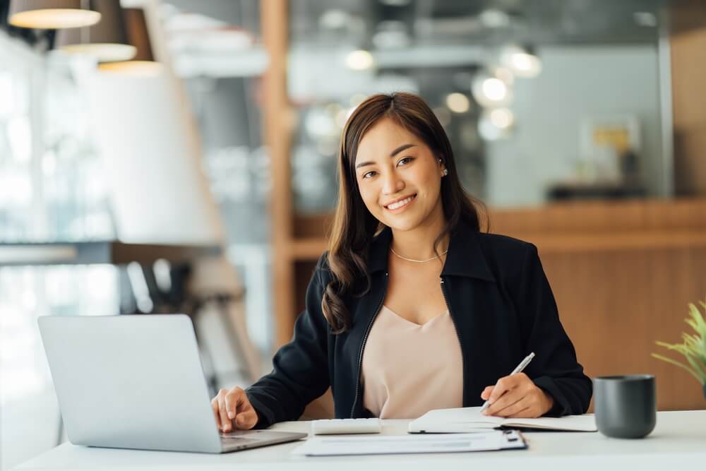 CMO_Portrait of an Asian young business Female working on a laptop computer in her workstation.Business people employee freelance online report marketing e-commerce telemarketing concept.