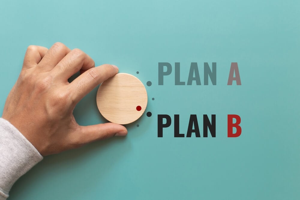 a/b testing_Hand choose wooden with the word PLAN A to PLAN B on green background. Business concept