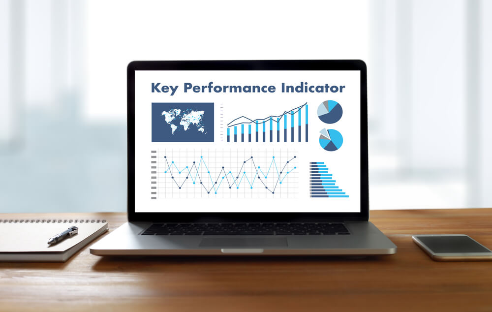 KPI_KPI acronym (Key Performance Indicator) Business team hands at work with financial reports and a laptop