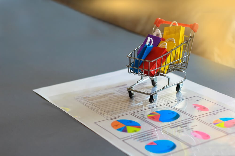 eCommerce analytics_Ecommerce Shopping and Market Share Concepts: Putting Trolley on Report Paper in the Office.