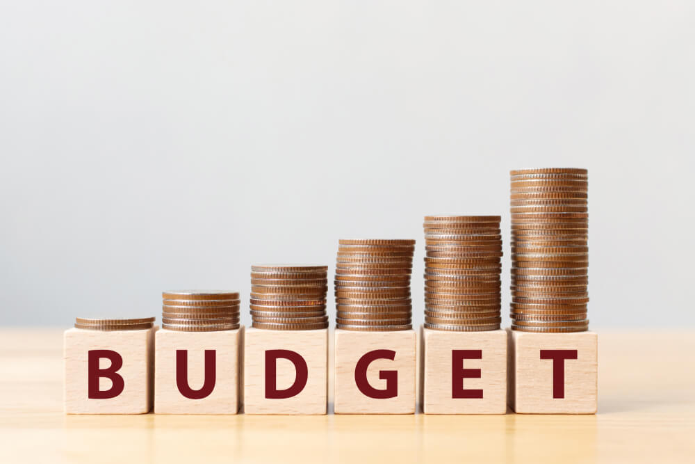 budget_Coins on stack stair as step growing growth and wooden cube block with word BUDGET. Money annual budget concept