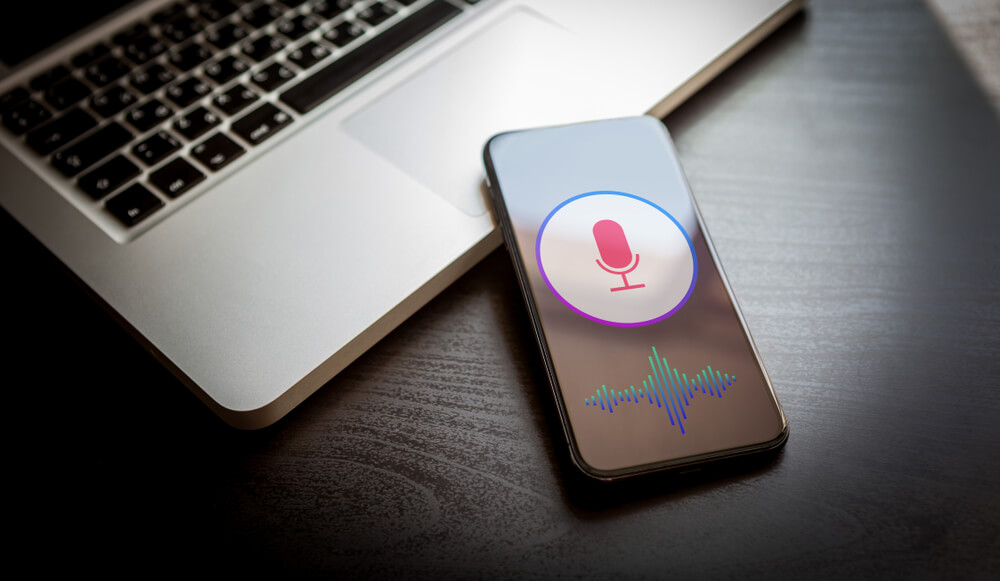 voice search_Speech recognition concept - close-up mobile phone with siri microphone icon and wave sound symbol. Personal voice assistant, deep learning application on smartphone screen.
