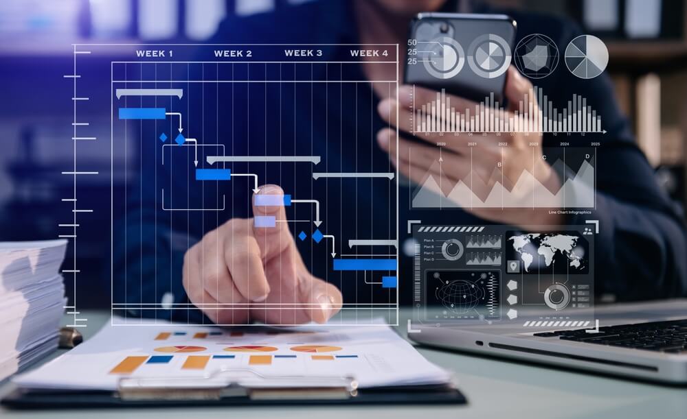 project management_Businessman hand Project manager working and update tasks and Gantt chart scheduling virtual diagram.with smart phone, tablet and laptop in modern office.