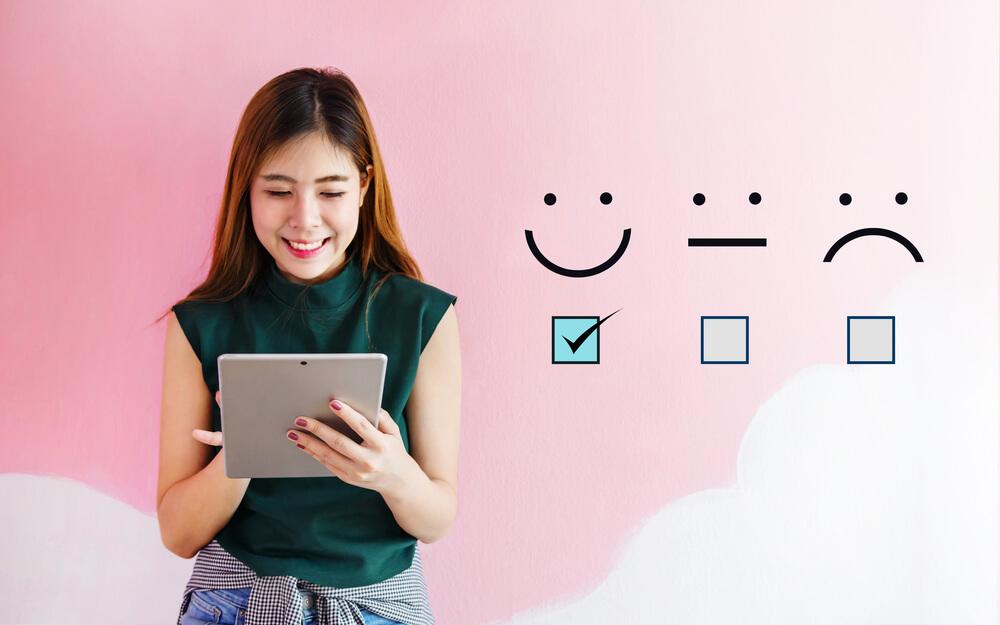 customer loyalty_Customer Experience Concept, Happy Client Woman holding digital Tablet with a checked box on Excellent Smiley Face Rating for a Satisfaction Survey