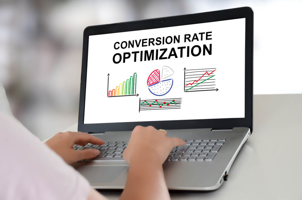 conversion rate_Woman using a laptop with conversion rate optimization concept on the screen
